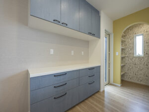 キッチンの後ろには、キッチンの面材とお揃いのカップボード。二の字のカウンターにはいろいろな調理家電が設置できます。